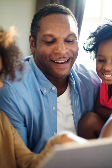 Father reading to daughters